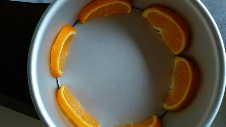 香橙慕斯蛋糕,先把六片橙子贴着模具
