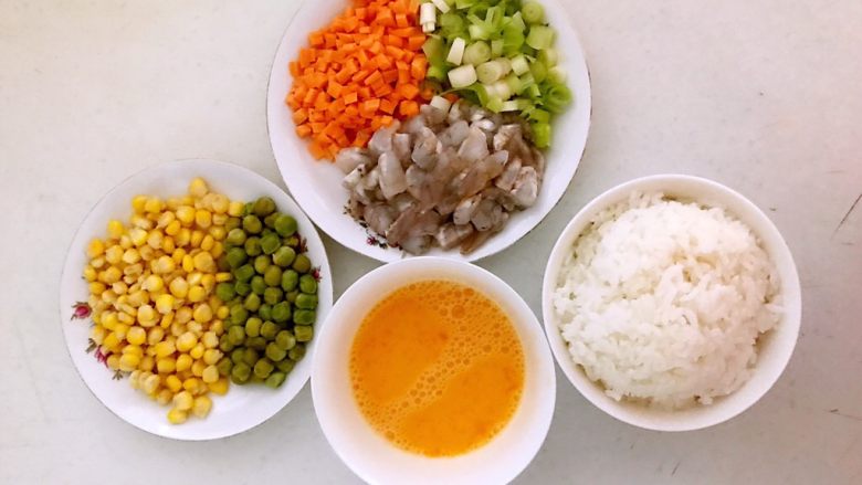 什锦虾仁焗饭,把玉米和青豆用开水烫一下，虾仁和胡萝卜切成小丁，葱切成末，鸡蛋液调匀
