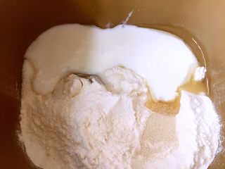 酸奶吐司（一次发酵法）,依次把面粉、酸奶、糖、盐、酵母、玉米油倒进面包机桶内，开启和面程序