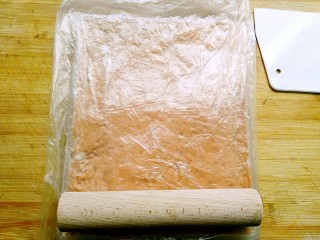花生高钙牛轧糖,垫上烹调纸或抹层油的保鲜袋，擀平