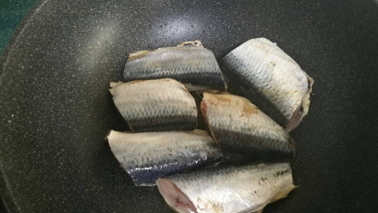 红烧鲭鱼,锅烧热放油，放入鲭鱼煎制。注意油不要放多了，鲭鱼经过高温煎制自身会煎出一些鱼油。