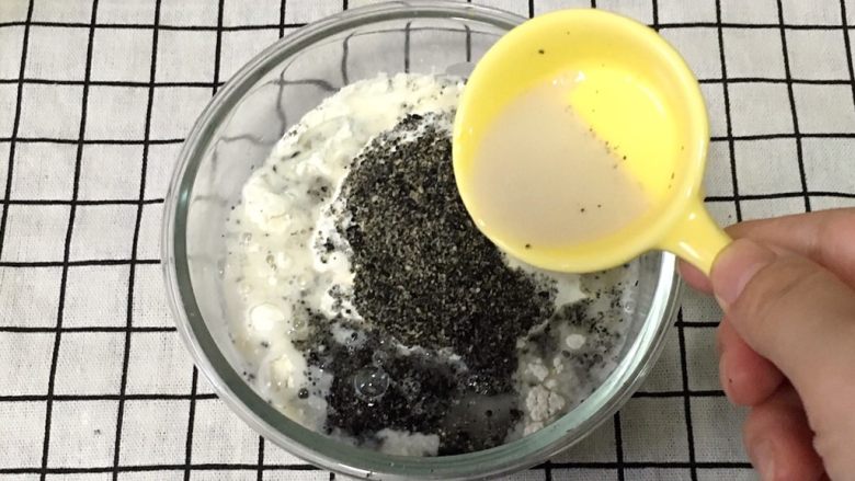 黑芝麻肉龙卷,将面粉，黑芝麻粉，酵母，和余下的水装在一个容器里。