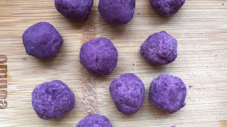 紫薯水晶球,取一小团紫薯糯米团，用手搓圆，完成一个一个紫薯小球球。