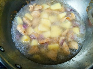 土豆炖鸡肉,倒入土豆后翻炒几下，加入水，没过土豆和鸡肉。