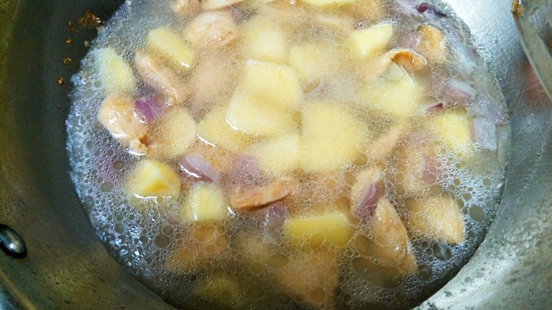 土豆炖鸡肉,倒入土豆后翻炒几下，加入水，没过土豆和鸡肉。