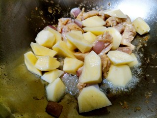 土豆炖鸡肉,放鸡肉翻炒至发白时，倒入切好的土豆块。(泡土豆的水不要倒)