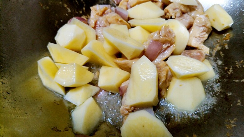 土豆炖鸡肉,放鸡肉翻炒至发白时，倒入切好的土豆块。(泡土豆的水不要倒)