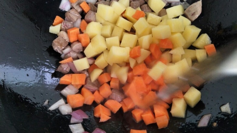 电饭煲羊肉手抓饭,洋葱煸出香味，加入土豆丁和胡萝卜丁。