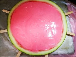 西瓜冰糕,混合好的奶油液倒入西瓜皮里。表面边缘处抹匀。