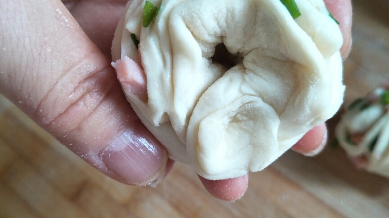 火腿香葱小花卷,在左手食指下捏实两端，抽出食指。
