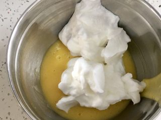 肉松小贝,取三分之一的蛋白霜放入蛋黄糊，用刮刀翻拌均匀。