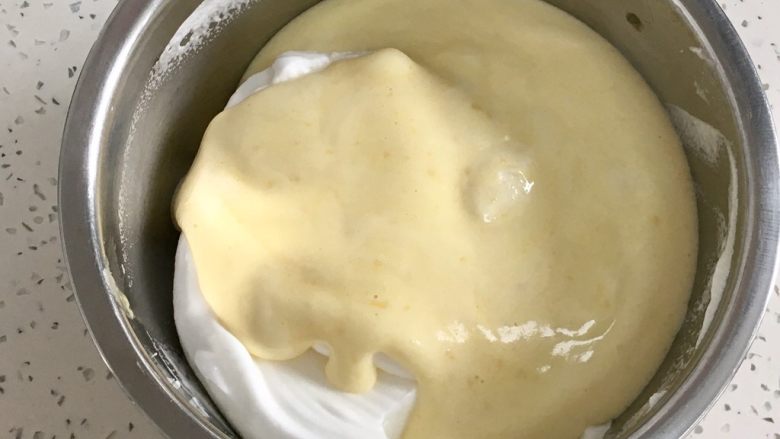 肉松小贝,把拌好的蛋黄糊倒入蛋白霜盆里，用刮刀翻拌均匀。