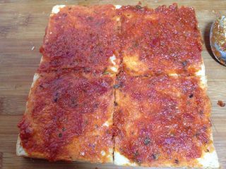 吐司魔方披萨,烤好的吐司片取出，烤的那面向上涂满披萨酱。如果喜欢自己制作披萨酱的可以参考我空间里的做法。