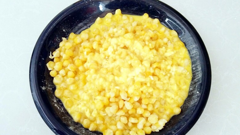 香酥玉米粒,玉米粒中倒入蛋液糊拌匀。