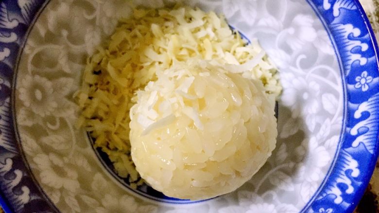 椰糖椰丝糯米饭团,将椰糖糯米饭放入提前准备好的椰丝碗内