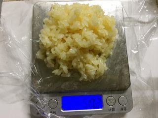 椰糖椰丝糯米饭团,电子秤上垫一张25cm见方的保鲜膜，称量50克椰糖糯米饭