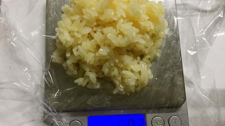 椰糖椰丝糯米饭团,电子秤上垫一张25cm见方的保鲜膜，称量50克椰糖糯米饭