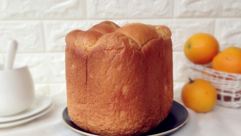 面包机版香橙面包,烘烤结束，立即将面包倒出来，放晾架上晾凉。