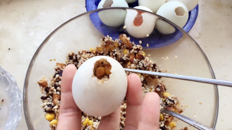 糯米蛋,现在把拌好的材料灌入只剩下蛋黄的鸭蛋壳里，用筷子轻轻把鸭蛋里的材料压实，注意不要把蛋壳捅破