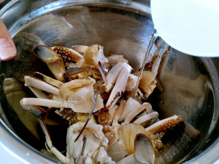 美味香炒螃蟹,把切好的螃蟹加入白酒。