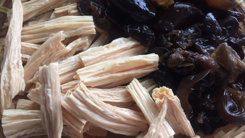腐竹木耳羊肉砂锅煲,加入泡发好的腐竹段和黑木耳，翻炒均匀调味。