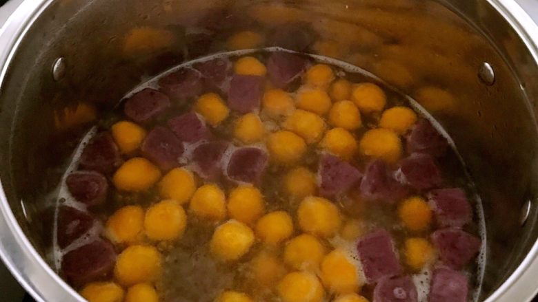 菠萝汁Q弹芋圆,锅内加水烧开后加入适量南瓜和紫薯芋圆，煮到芋圆飘起来3分钟后即可