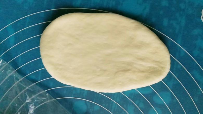 葱香芝士面包,取一面团擀成椭圆形。