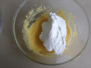 金枪鱼香肠蛋糕,将1/3打发好的蛋白霜加入到蛋黄糊里。