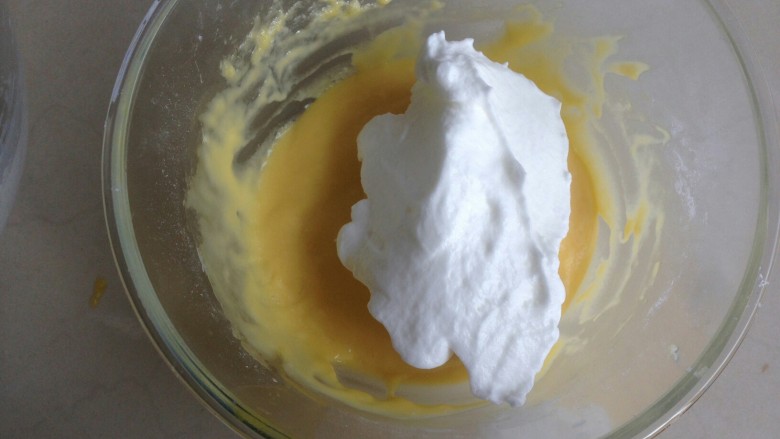 金枪鱼香肠蛋糕,将1/3打发好的蛋白霜加入到蛋黄糊里。