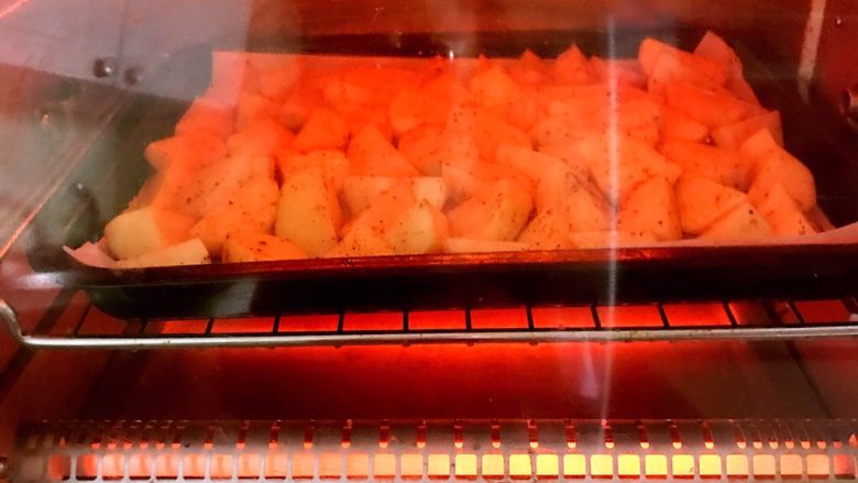 外焦内软的椒盐土豆,把烤盘放进预热好的烤箱里，上下火210W烤15分钟