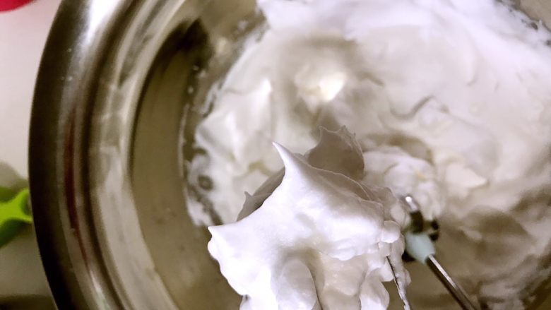 戚风杯蛋糕,在蛋白里滴几滴柠檬汁，用电动打蛋器打成粗泡，然后将20g糖分三次陆续边打边加入到蛋白内，打成干性发泡（如图，小短尖）。然后将蛋白放入冰箱冷藏。