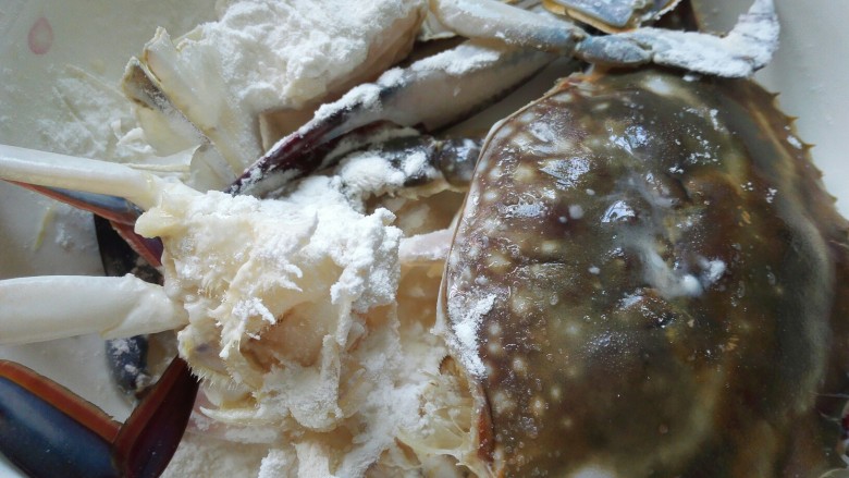 梭子蟹炒年糕,把生粉倒在梭子蟹上，均匀的裹在蟹肉上
