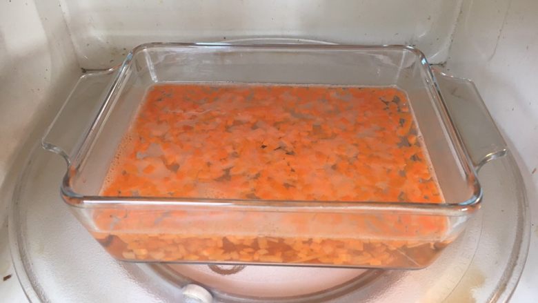 鲜虾土豆泥,容器里放适量的水，微波炉加热，水开后，放入胡萝卜丁，加热2分钟。