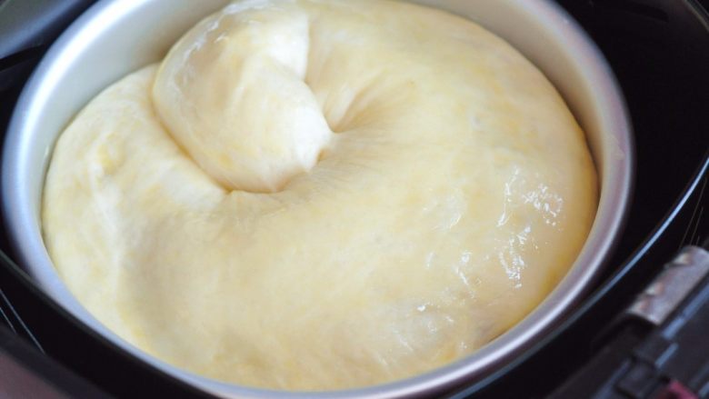 苹果肉桂面包,面团发酵至两倍大，启动空气炸锅，180度预热5分钟，然后将面包表面刷上蛋液，放入空气炸锅的炸篮中。