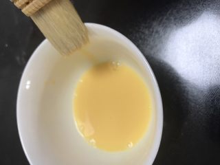 广式巧克力莲蓉月饼,一个蛋黄加10克水调均匀后过筛两边，刷子要在碗边刮两下再刷到月饼上面，蛋液太多表面容易糊