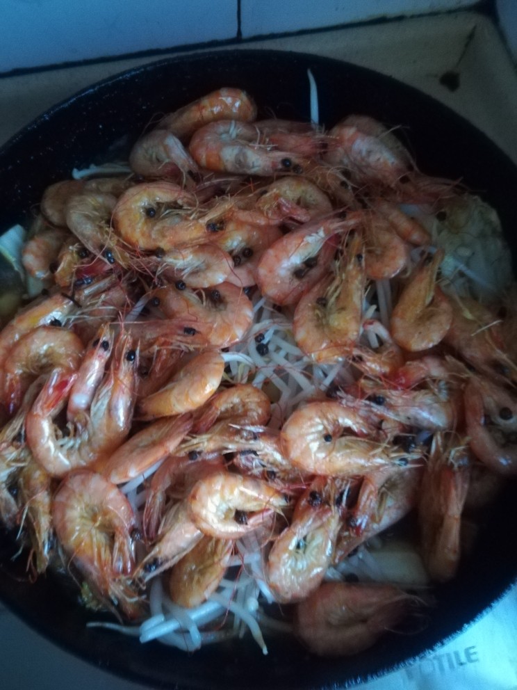 虾配菜,把炒好的虾放在锅的上面，盖上盖炖中火8分钟。