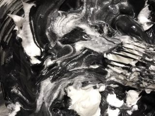 黑·竹炭咸奥利奥蛋糕卷,混匀后将剩下的蛋白加入面糊，用手动打蛋器或者刮刀拌匀，动作要快，避免蛋白消泡