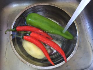 酸辣土豆丝,首先将土豆去皮后洗净，红辣椒和青辣椒洗净待用