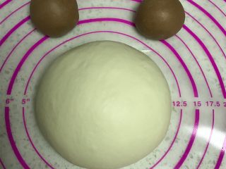 轻松熊吐司--又一款哄娃利器, 将大面团滚圆，可可面团均匀分割成2份滚圆。加盖保鲜膜松弛20分钟