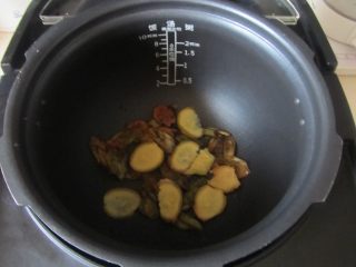 烤鸡（电饭煲版）,将腌制的葱姜蒜部分垫入电饭煲的底部；