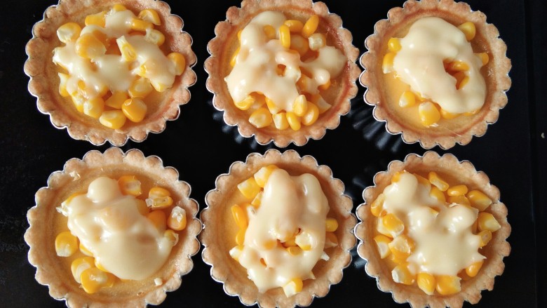 玉米奶酪蛋挞,再在每个蛋挞上倒入一小勺奶酪，放入烤箱中180℃继续烘烤三分钟即可。