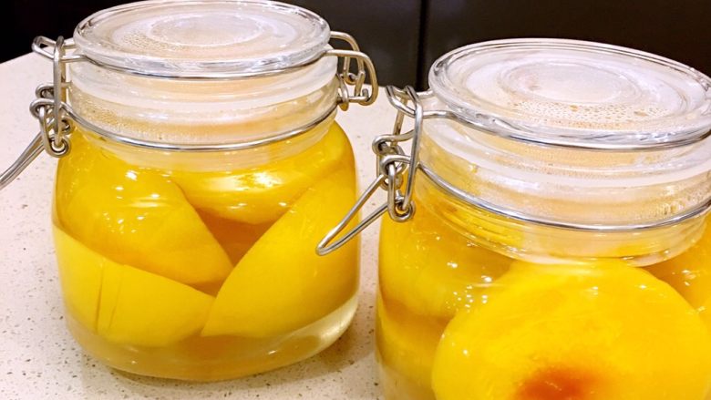 黄桃罐头,黄桃煮完以后趁热装瓶密封，利用热胀冷缩的原理可以使罐头彻底密封，这样可以保存更长时间。