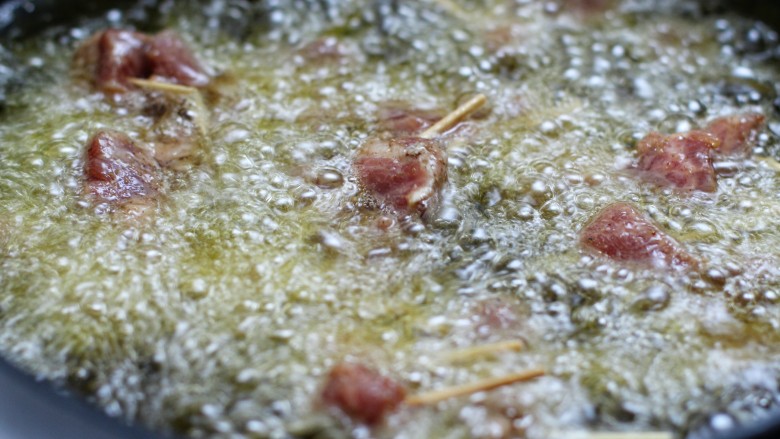牙签肉,锅中放适量油烧至八成热，放入肉串中火炸制