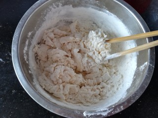 包菜馅素包子,用筷子把面搅成棉絮状。