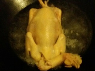 白切鸡,锅里放清水烧开，把鸡放进锅里滚一下，水量最好浸沒鸡身。