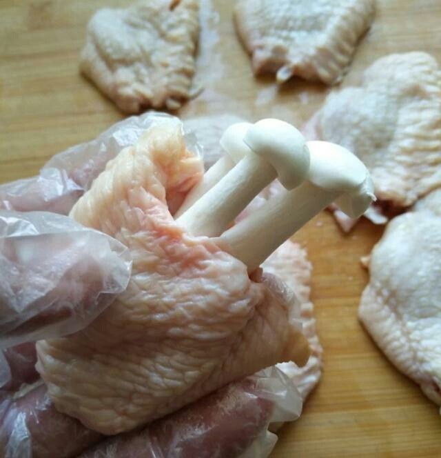 （家常菜）鸡翅包白玉菇,白玉菇去掉根部然后洗干净，把白玉菇塞入鸡翅中里