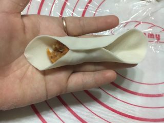 金鱼饺子,面皮对折，将中间部位的面皮轻轻捏紧，看上图。