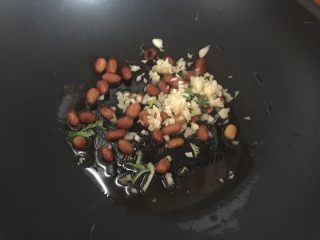 酸菜鱼,锅里热油后放入花生米、花椒粒和蒜末爆香爆酥