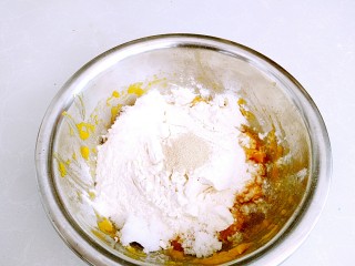 元宝南瓜豆沙包,南瓜泥温热后放入面粉，发酵粉，砂糖。