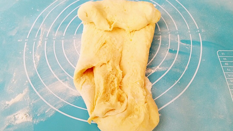 元宝南瓜豆沙包,取出面团，放至揉面垫用力揉面5分钟。